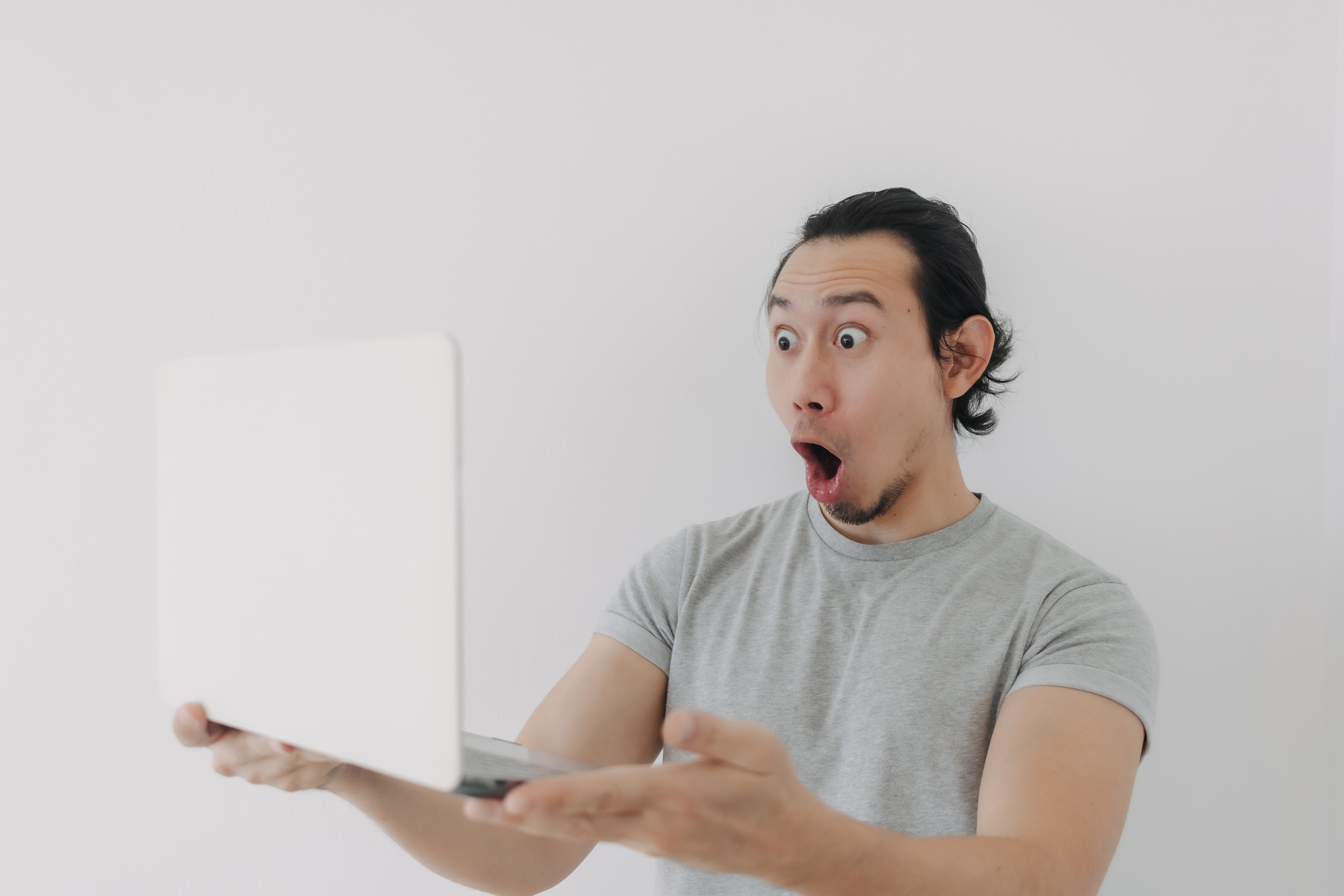 Shocked and Surprised Face of Man Looking at the Laptop in His Hand.